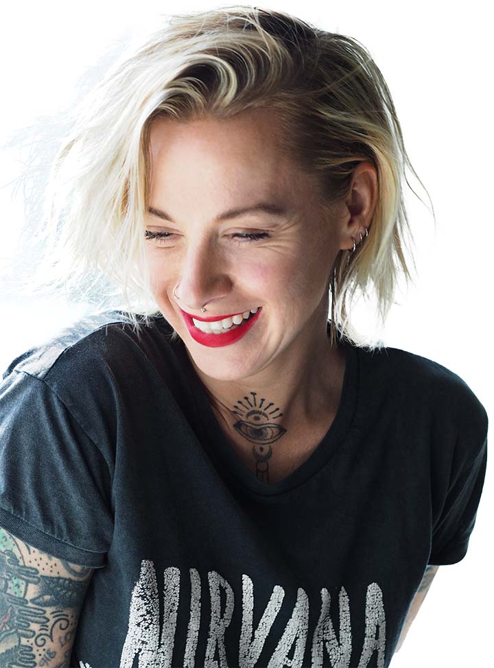 Melissa Meszaros author portrait, smiling in Nirvana t-shirt